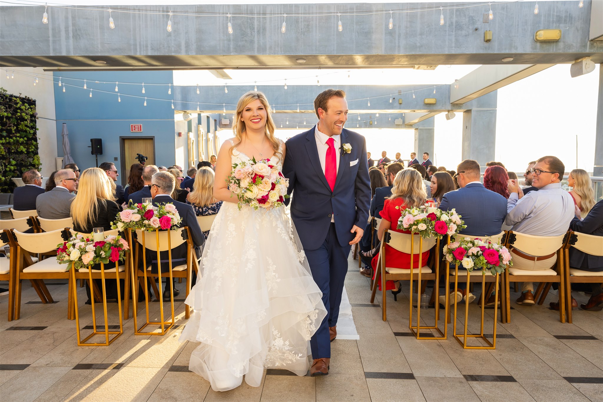 Harbor-front reception recessional with a lush bridal bouquet
